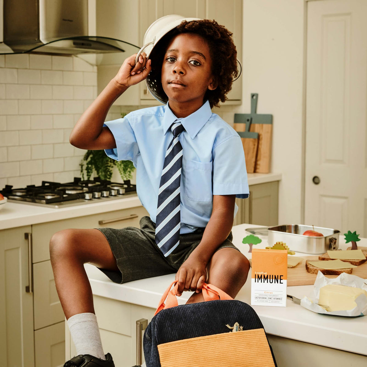 Child sitting on a kitchen counter with Leapfrog IMMUNE